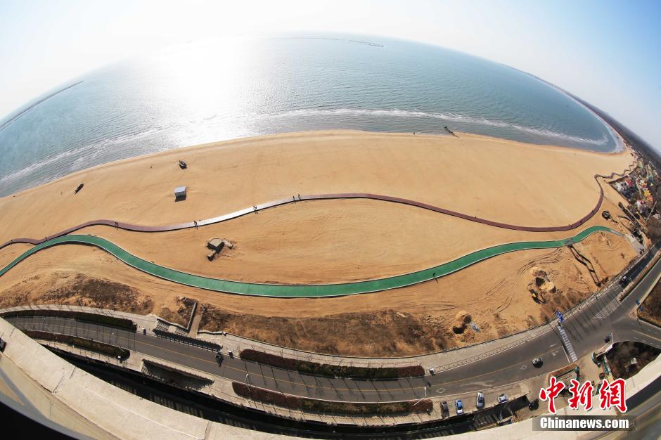 3月13日，秦皇島萬米臨海沙灘木棧道。據(jù)了解，該木棧道全長約4200米，與北戴河區(qū)原有的7500米木棧道對接后全線總長度1.17萬米，整個木棧道東起秦皇島體育基地游船碼頭，西至北戴河濕地公園，呈波浪形蜿蜒10.4公里海岸線。 中新社發(fā) 曹建雄 攝 CNSPHOTO