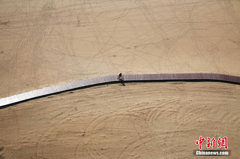 3月13日，秦皇島萬米臨海沙灘木棧道。據(jù)了解，該木棧道全長約4200米，與北戴河區(qū)原有的7500米木棧道對接后全線總長度1.17萬米，整個木棧道東起秦皇島體育基地游船碼頭，西至北戴河濕地公園，呈波浪形蜿蜒10.4公里海岸線。 中新社發(fā) 曹建雄 攝 CNSPHOTO